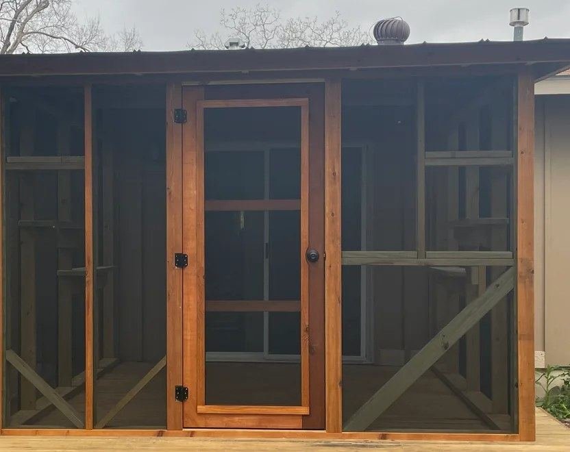 Hand-built cedar screen door with two horizontal supports and a real doorknob, on a finished catio