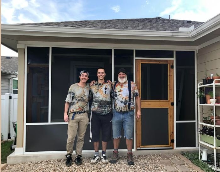 Ben, his father and a friend in their custom tie-dye CatManDo shirts, in front of a finished screened room