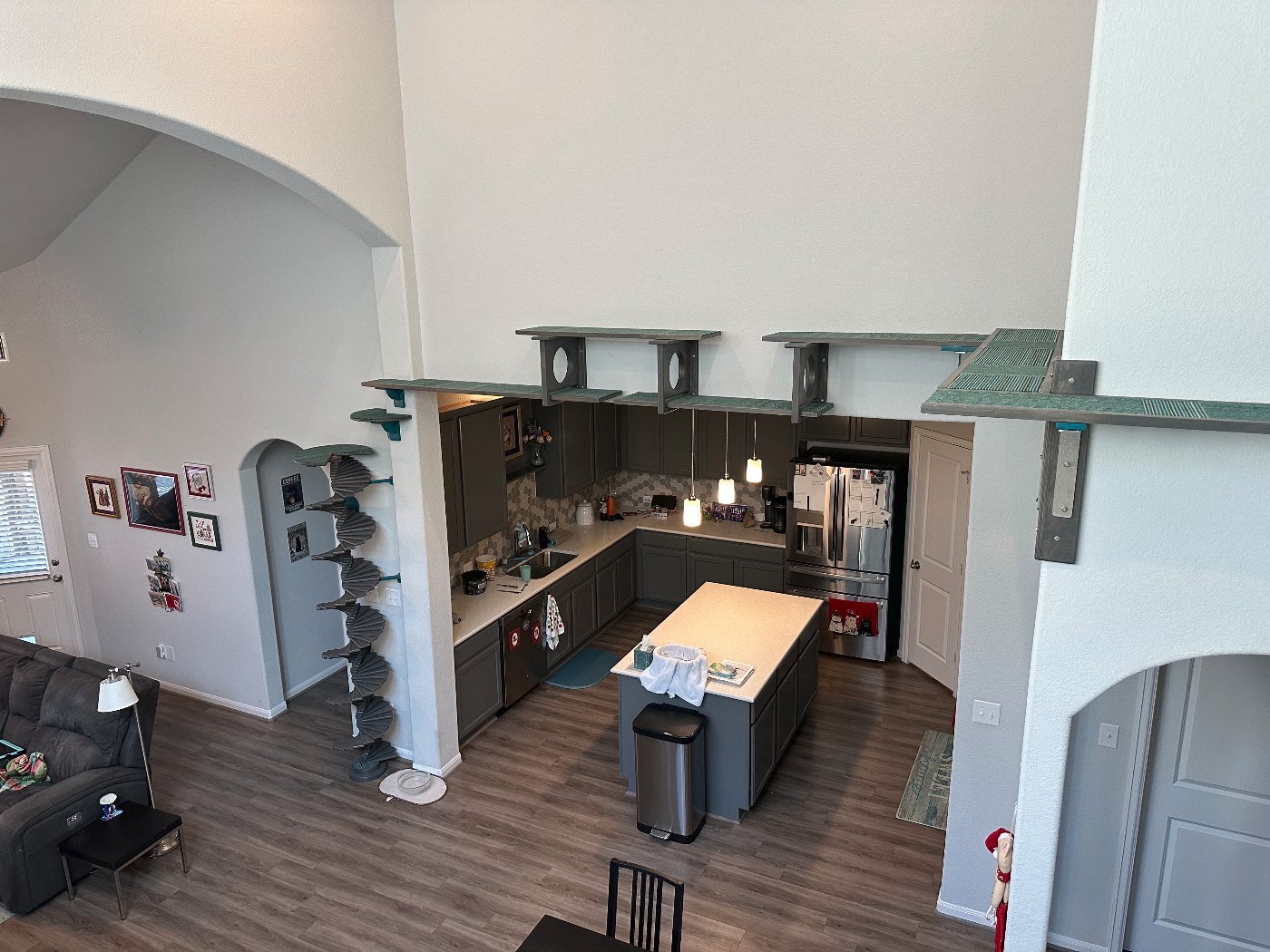 Grey cat shelves and bridges running high across a two-storey living room and over the kitchen archways
