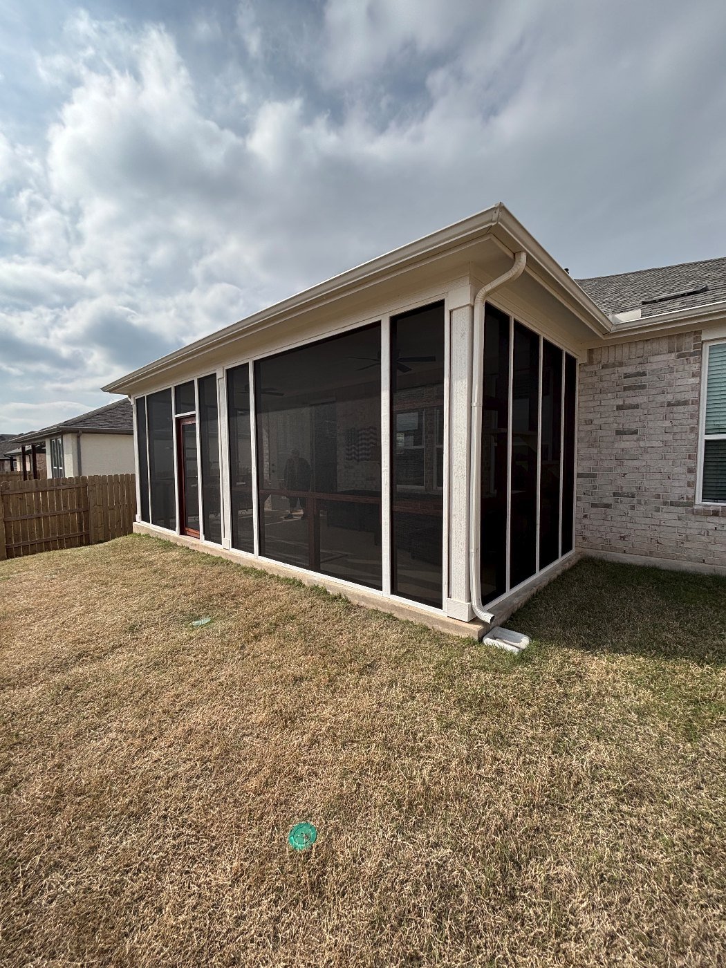 The same patio fully screened corner to corner with a cedar door, matched to the house trim