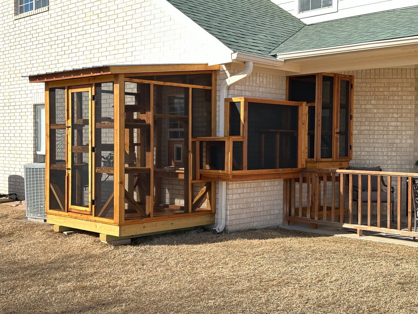 A large cedar window Signature catio with a tunnel running to a smaller enclosure on the same wall