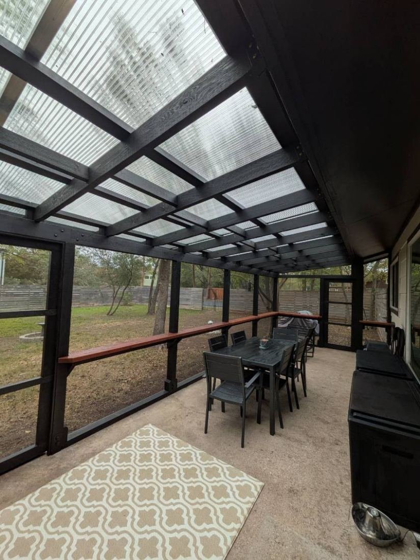 Inside the same Signature catio, looking up at the black cedar roof framing and translucent panels