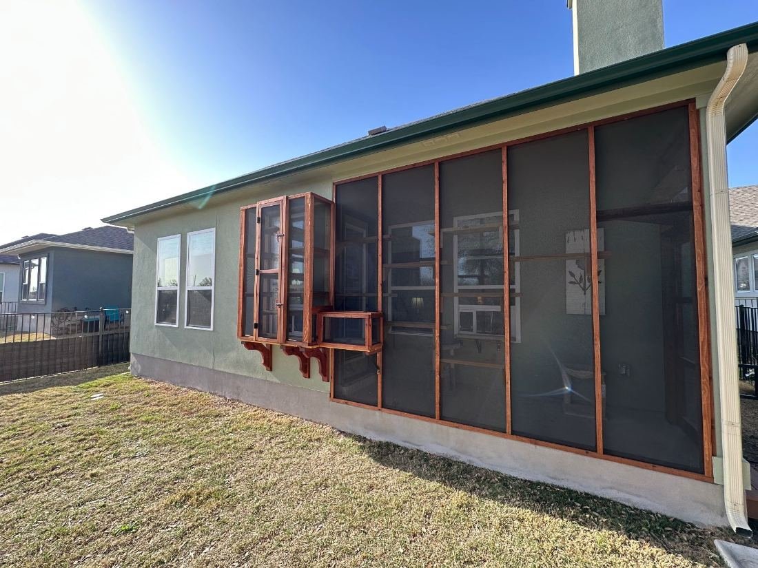 Two window catios on cedar brackets along one wall of an Austin house